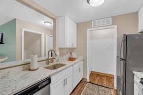 Southgate apartment for rent - A kitchen with white cabinets and a marble countertop.
