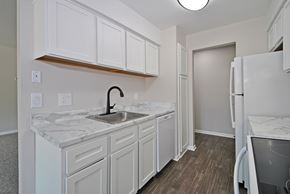 Livonia apartment for rent - A kitchen with white cabinets and a marble countertop.