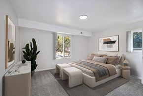 Livonia apartment for rent - A bedroom with a large bed and a plant.