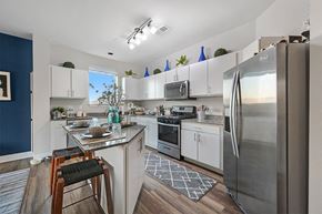Aurora apartment for rent - A kitchen with white cabinets and a stainless steel refrigerator.