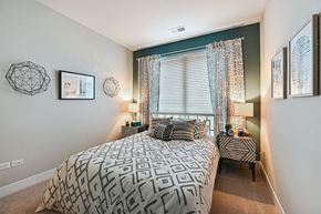 Aurora apartment for rent - A bedroom with a large bed and a window with curtains.