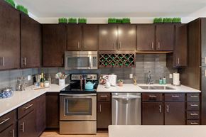 St. Louis Park apartment for rent - a modern kitchen with stainless steel appliances and wooden cabinets