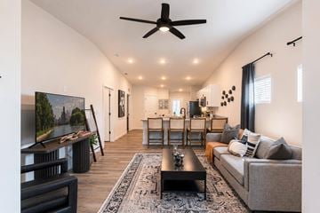 Kansas City apartment for rent - A living room with a grey couch, a black coffee table, and a television on the left side.