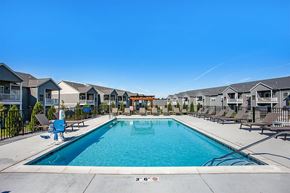 Rockford apartment for rent - A large swimming pool surrounded by a fence and chairs.