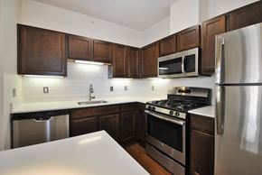 Ann Arbor apartment for rent - A kitchen with dark wood cabinets and stainless steel appliances.