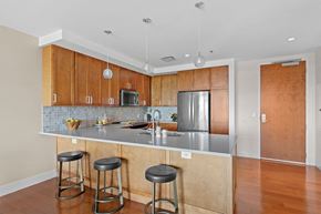 Cleveland apartment for rent - A kitchen with wooden cabinets and a stainless steel refrigerator.