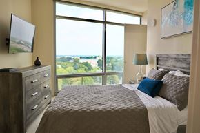 Cleveland apartment for rent - A bedroom with a large bed and a view of the outdoors through the window.