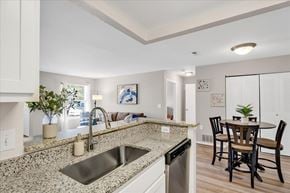 Orion Charter Twp apartment for rent - A kitchen with a granite countertop and a dining table with chairs.