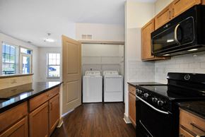 Detroit apartment for rent - A kitchen with a black stove and white dishwasher.