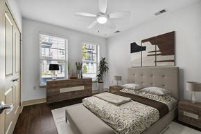 Detroit apartment for rent - A bedroom with a large bed and a ceiling fan.