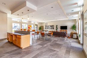 Detroit apartment for rent - A modern open plan kitchen and living room with a grey tiled floor.