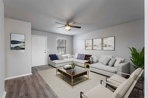 Rogers apartment for rent - A living room with a white couch, a coffee table, and a ceiling fan.