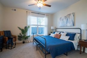Chaska apartment for rent - a bedroom with a bed and a ceiling fan and a window