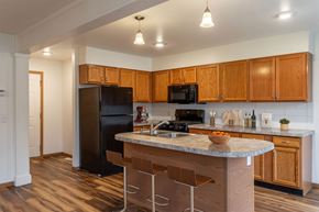 Portage apartment for rent - A kitchen with wooden cabinets and a granite countertop.