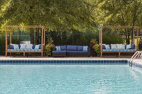 New Hudson apartment for rent - A pool with a blue tinted water and a wooden bench with white cushion.