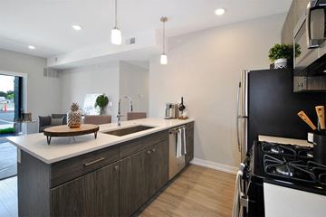 Troy apartment for rent - A modern kitchen with a black refrigerator and wooden cabinets.