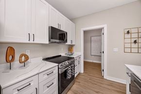 West Des Moines apartment for rent - A kitchen with white cabinets and a black stove top.