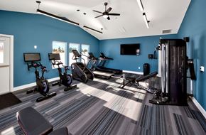 West Des Moines apartment for rent - A gym with a variety of equipment including treadmills, stationary bikes, and a weight machine.