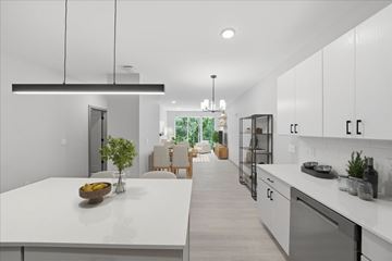 Plymouth apartment for rent - A modern kitchen with white cabinets and a large island.