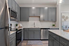 Mcmurray apartment for rent - A kitchen with grey cabinets and a white countertop.
