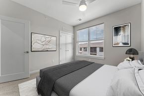Mcmurray apartment for rent - A bedroom with a large bed and a window overlooking a building.