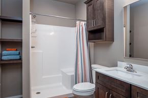 Rogers apartment for rent - A bathroom with a toilet, sink, and shower.