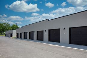 Rogers apartment for rent - A long building with black garage doors.