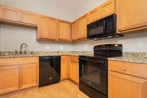 Pikeville apartment for rent - A kitchen with wooden cabinets and black appliances.