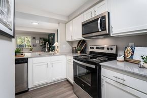 Amelia townhouse for rent - a kitchen with stainless steel appliances and white cabinets