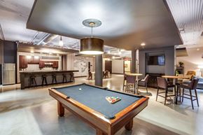 St. Paul apartment for rent - A pool table is in the middle of a room with a bar and a television.