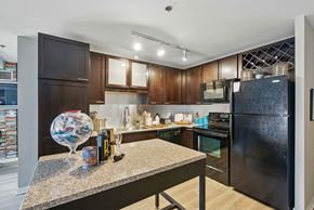 Chicago apartment for rent - A kitchen with dark wood cabinets and a black refrigerator.