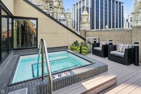 Chicago apartment for rent - A hot tub on a balcony with a view of a cityscape.
