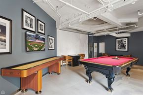 Chicago apartment for rent - A pool table with a red cloth and a pool cue on it.