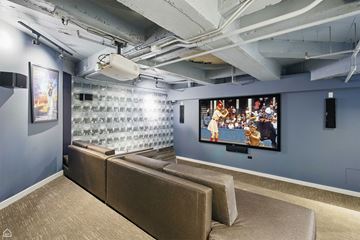 Chicago apartment for rent - A modern living room with a large couch and a television.