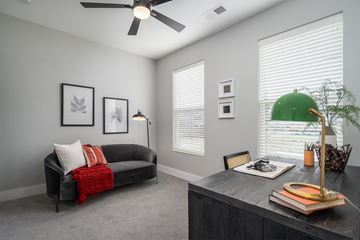 Cincinnati apartment for rent - A living room with a black couch and a ceiling fan.