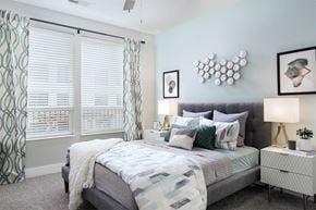 Cincinnati apartment for rent - A bedroom with a bed, nightstand, and wall art.