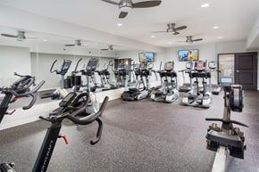 Cincinnati apartment for rent - A spacious gym with a variety of exercise equipment including treadmills, stationary bikes, and elliptical machines.