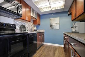 Detroit apartment for rent - A kitchen with black appliances and wooden cabinets.
