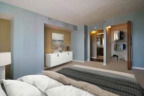 Detroit apartment for rent - A bedroom with a bed, dresser, and mirror.