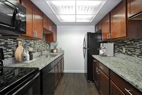 Detroit apartment for rent - A kitchen with black appliances and wooden cabinets.