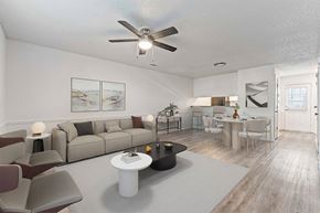 Bentonville apartment for rent - A living room with a grey couch, a white coffee table, and a ceiling fan.