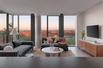 Shaker Heights apartment for rent - A modern living room with a grey sofa, a white coffee table, and a television on a wooden cabinet.