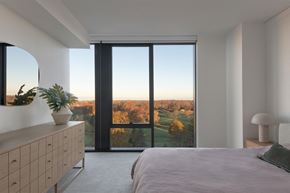 Shaker Heights apartment for rent - A bedroom with a large bed and a view of the outdoors through a large window.