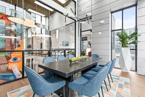 Cleveland apartment for rent - A modern dining room with a glass table and blue chairs.