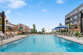 Cleveland apartment for rent - A large outdoor swimming pool surrounded by sun loungers and umbrellas.