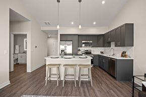 Ankeny apartment for rent - A modern kitchen with a center island and bar stools.