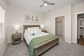 Ankeny apartment for rent - A bedroom with a bed, nightstand, and a ceiling fan.