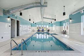 Kenosha apartment for rent - a swimming pool in a room with blue and white walls and a ladder over it