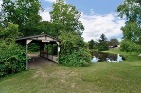 Ann Arbor apartment for rent - A gazebo is surrounded by greenery and a pond.