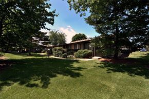 Ann Arbor apartment for rent - A house with a lawn and trees in front of it.